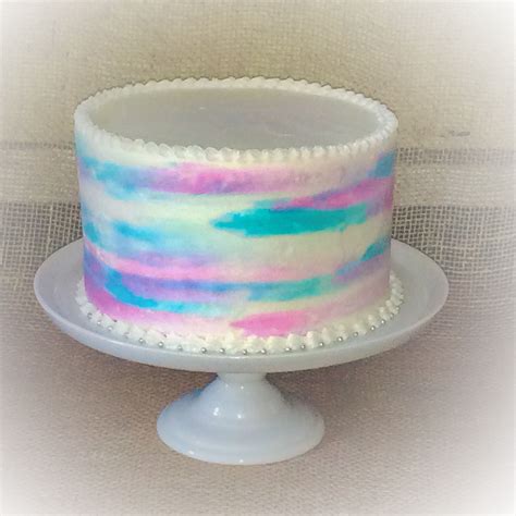 There Is A White Cake With Pink And Blue Icing On It