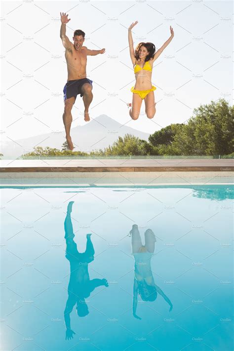 Cheerful Couple Jumping Into Swimming Pool ~ Photos ~ Creative Market