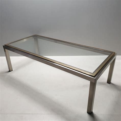 Contemporary coffee table, late 20th c., glass tabletop with printed double hemisphere world map, mahogany frame, rising on square legs with brass string inlay, joined by h stretcher, approx 15h, 40. Vintage chrome & brass coffee table with a glass top | #106028