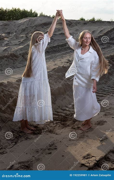 Two Attractive Young Twin Sisters Posing At Sand Quarry In Elegant