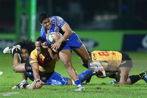 Anthony Milford Of Samoa Is Held Up By Paul Aiton Of Papua New Guinea