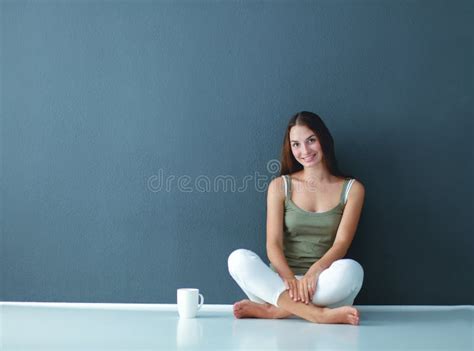 A Beautiful Young Healthy Sitting On The Floor With A Cup Of Tea Or