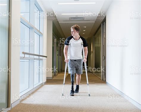 Young Man With Prosthetic Leg On Crutches Stock Photo Download Image