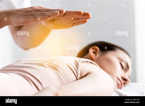 Cropped View Of Healer Standing Near Woman Lying With Closed Eyes And