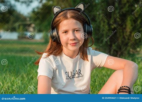 Portrait Of A Beautiful Red Haired Teenage Girl In Headphones In Nature 12 Year Old Girl