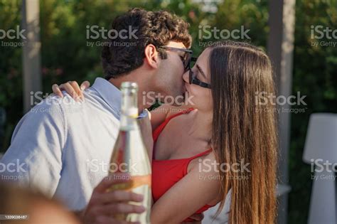 Photo Libre De Droit De Jeune Couple Sembrassant Dans Le Jardin De La Terrasse Tenant Une