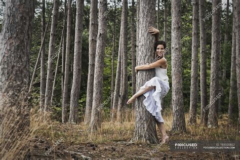 Woman Hugging Tree While Dance And Looking In Camera In Forest Tree