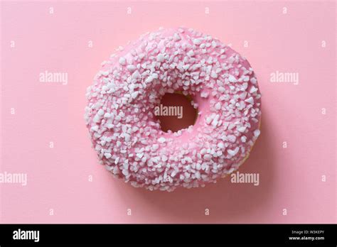 Pink Frosted Donut Sprinkled With Crystal Sugar Isolated On Pink