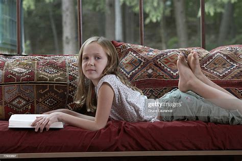 Girl Lying On Sofa Holding Book Portrait Bildbanksbilder Getty Images
