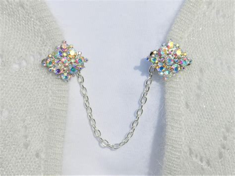 this elegant sweater pin that features rhinestones that reflect all the colors of the light like