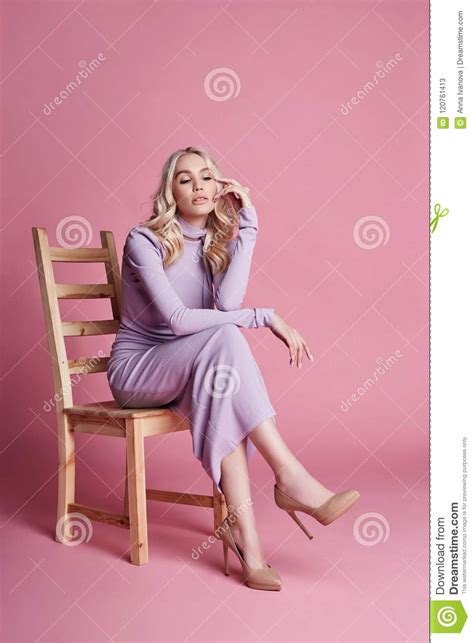 Fashion Beautiful Blonde Woman In Knitted Closed Long Dress Sitting On