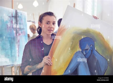 Portrait Female Artist Holding Showing Painting In Art Class Studio