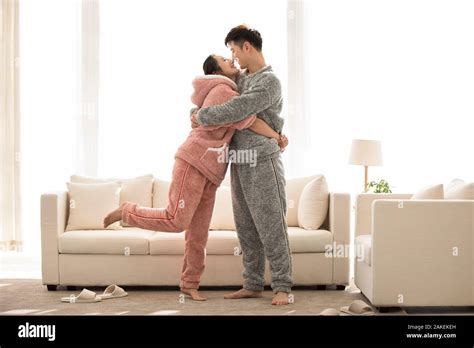Happy Young Chinese Couple Embracing In Living Room Stock Photo Alamy