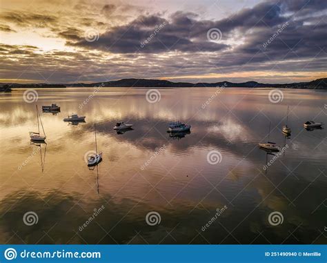 Aerial Sunrise Waterscape With Boats Reflections And Cloud Filled Sky