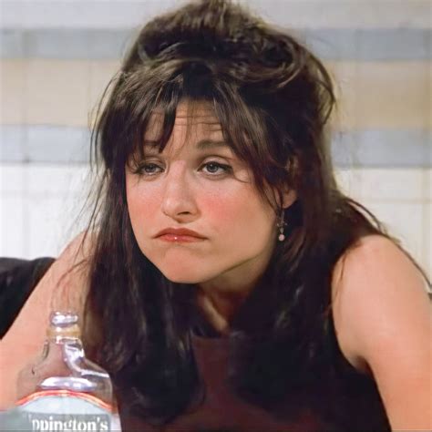 A Close Up Of A Person Sitting At A Table With A Bottle In Front Of Her