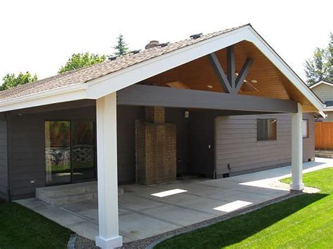 A Covered Patio With An Attached Carport In The Middle Of A Lawn Area