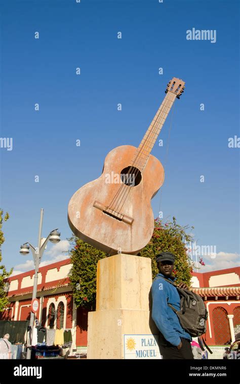 Statue Of A Guitar On The Market Of Fuengirola With A Looky Looky Man