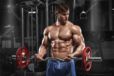 Muscular Man Working Out In Gym Doing Exercises With Barbell At Biceps Strong Male Naked Torso