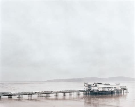 An Old Photo Of A Pier In The Middle Of The Ocean On A Foggy Day