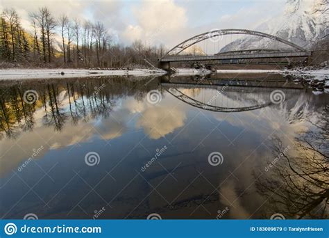 Winter Scene With Bridge And River Reflection In Northern Bc Stock
