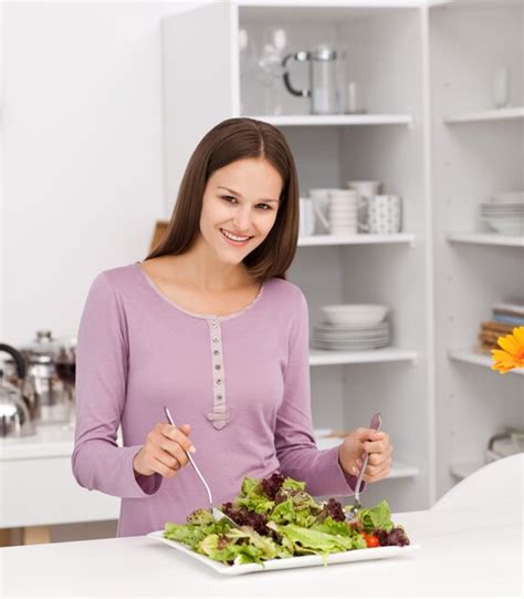 premium photo pretty woman preparing a salad standing in the kitchen