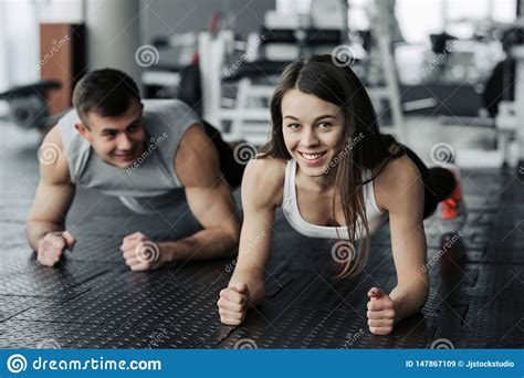 Young Muscular Couple Doing Doing Hard Workout At The Gym. Doing Plank In The Gym Stock Image 