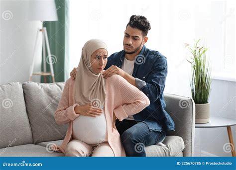 Caring Arab Husband Making Neck Massage To Pregnant Muslim Wife At Home