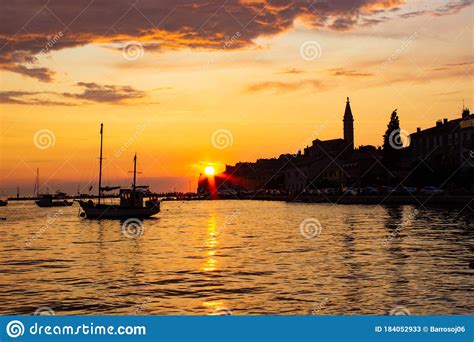 Sunset In Rovinj Croatia With A Boat Sailing In The Adriatic Sea And