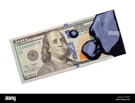 One Hundred Dollar Bill Covered In Black Oil Isolated On A White