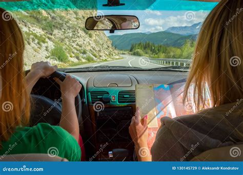 Two Young Woman Travelling By Car One In The Passenger Seat Look Stock