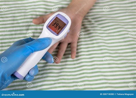 Doctor Measures Temperature Of Child On Hand Digital Thermometer