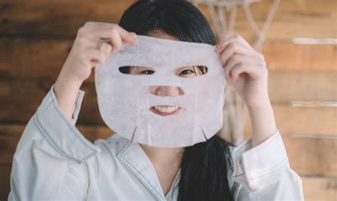 An Asian Chinese Teenager Girl Putting A Facial Sheet Mask On Her Face