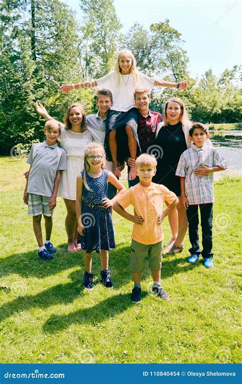 Happy Siblings Holding Sister On Their Shoulders Stock Photo Image Of