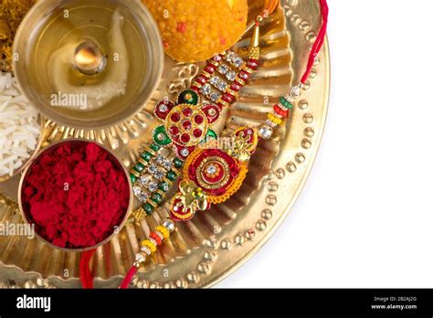 Indian Festival Rakhi With Rice Grains Kumkum Sweets And Diya On