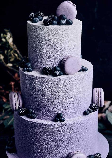 A Three Tiered Cake With Purple Frosting And Blueberries On The Top Layer
