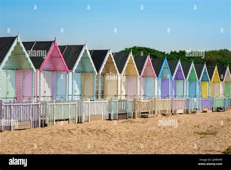 Mersea Essex Uk View In Summer Of Colourful Beach Huts Sited On The