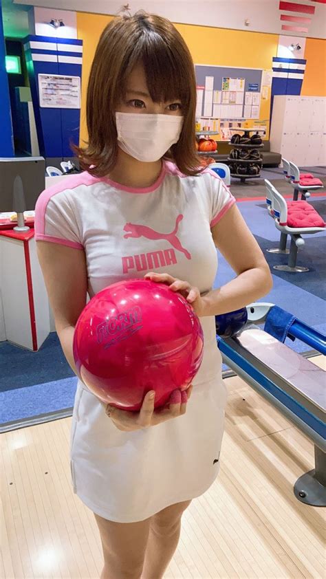 A Woman Wearing A Face Mask Holding A Bowling Ball