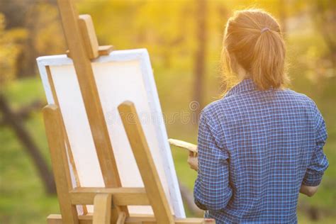 Young Woman Artist Standing Near An Easel And Looking At The Sun Stock