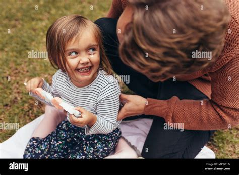 Sonriente Chica Sentada Con Su Padre En El Exterior Sosteniendo Un