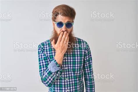 젊은 빨간 머리 아이리쉬 남자 캐주얼 셔츠와 선글라스 위에 고립 된 흰색 배경 지루 하품 피곤 한 손으로 입을 덮고 불안과 졸음 가리기에 대한 스톡 사진 및 기타 이미지