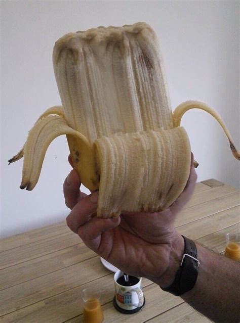 A Person Holding A Peeled Banana In Their Hand