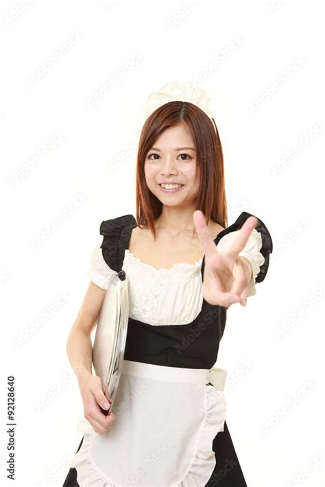 Young Japanese Woman Wearing French Maid Costume Showing A Victory Sign