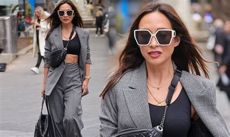 myleene klass gives a flash of her washboard abs in a grey pant suit for her smooth radio show
