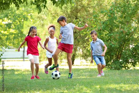 Cute Children Playing Football In Park Stock Photo Adobe Stock
