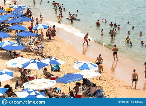 hundreds of people and tourists having fun on porto da barra beach under strong sun editorial