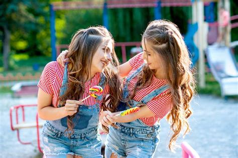 hermanas gemelas adolescentes besadas en ropa colorida con lópops en un fondo colorido imagen de