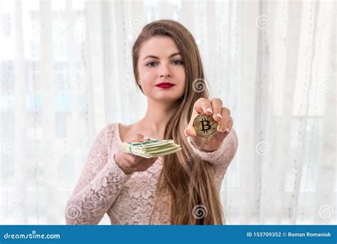 Young Woman Showing Bundle Of Dollars And Golden Bitcoin Stock Photo