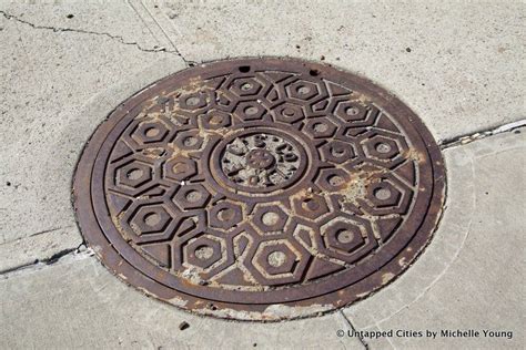 An Old Manhole Cover On The Sidewalk