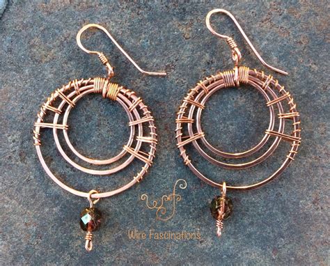 Two Pairs Of Wire Wrapped Hoop Earrings On Top Of A Stone Surface With