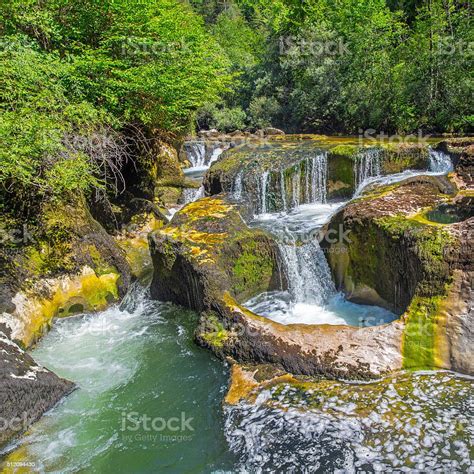 Rock Erosion From Waterhole With Waterfall In Middle Of Forest Stock